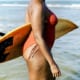 woman with liposuction carrying surfboard