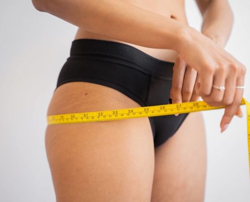 woman measuring her liposuction results